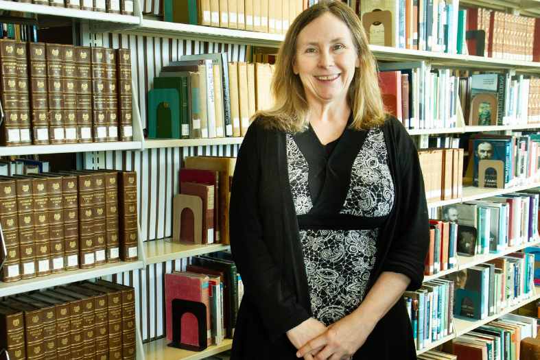 Headshot of professor in library. 